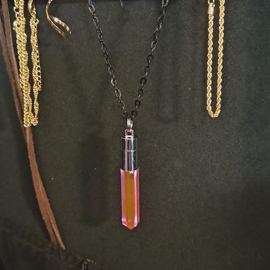 Close-up of a handcrafted pink LED pendant being twisted to activate glow, transitioning to a high-energy rave scene with the wearer dancing near a vibrant concert stage — Glo Nova light-up festival jewelry.