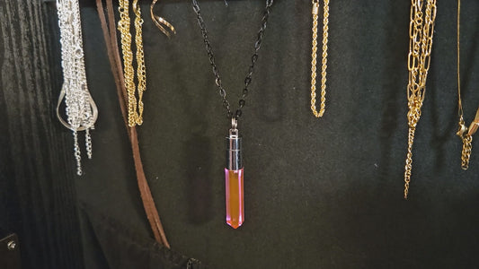 Close-up of a handcrafted pink LED pendant being twisted to activate glow, transitioning to a high-energy rave scene with the wearer dancing near a vibrant concert stage — Glo Nova light-up festival jewelry.