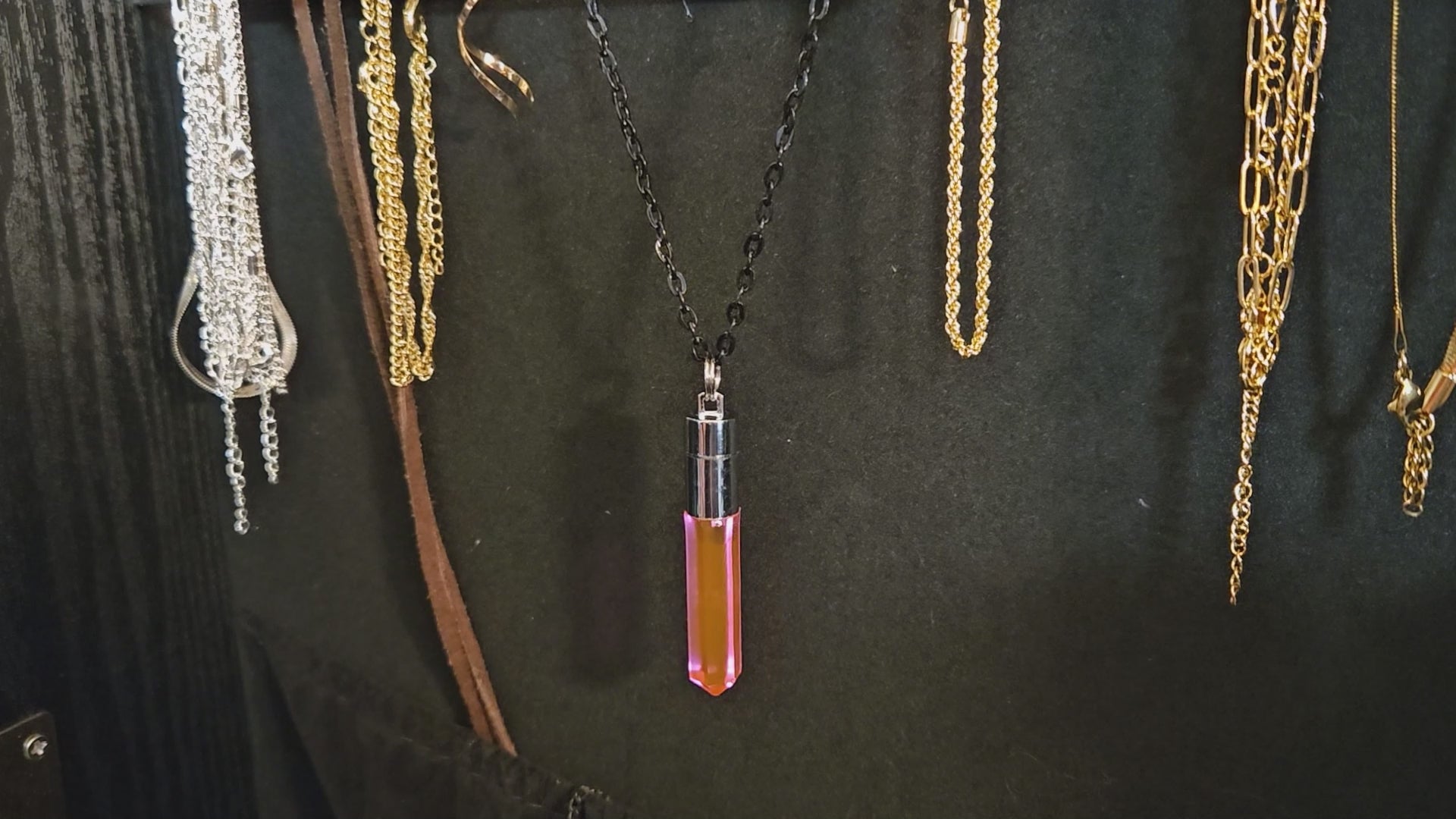 Close-up of a handcrafted pink LED pendant being twisted to activate glow, transitioning to a high-energy rave scene with the wearer dancing near a vibrant concert stage — Glo Nova light-up festival jewelry.